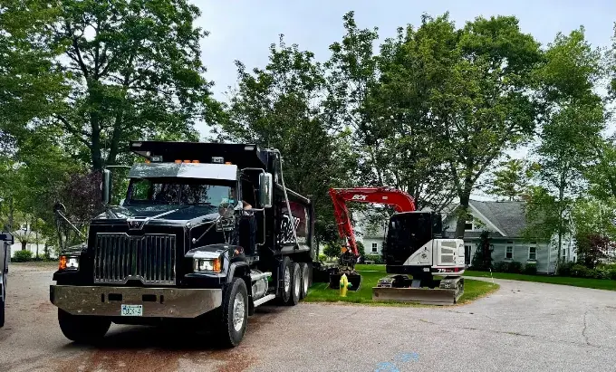 Finished commercial dump truck beside an excavator serviced by Midnight Detailing